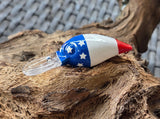 Fishing lure with American flag design on a piece of driftwood